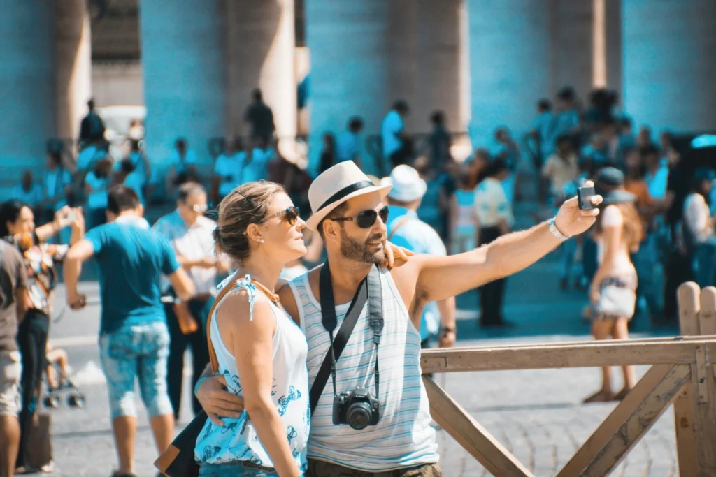 Turista o viajero? Una pareja de turistas haciendose un selfie en un sitio turístico y masificad