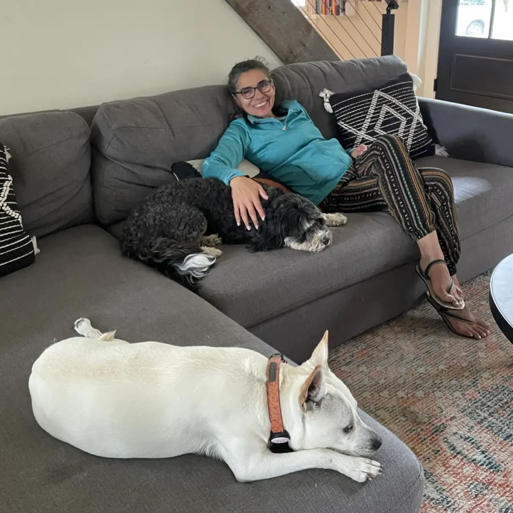 House sitting como funciona: Adriana descansando junto a dos perritas durante una experiencia de housesitting en una casa de los suburbios de Boston.